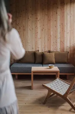 a woman walking through a living room with a couch at Max Green Forest Apartments in Siusi
