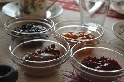 a group of bowls of chocolate and jam on a table at B&B La Tana dell'Orso - Die Bärenhöhle in Castello di Fiemme