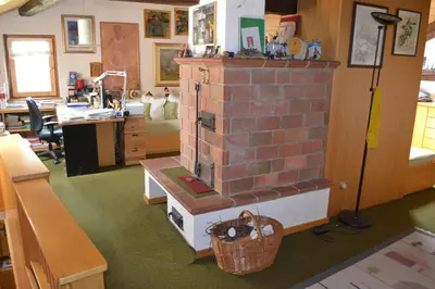 a living room with a brick fireplace in a room at B&B La Tana dell'Orso - Die Bärenhöhle in Castello di Fiemme