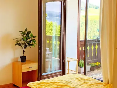 a bedroom with a bed and a large window at Vidora Apartments - Dolomites Escape in Alpe di Siusi (Seiser Alm) in Fiè