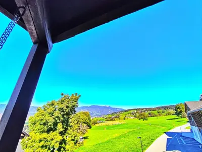 a view from a balcony of a green field and mountains at Vidora Apartments - Dolomites Escape in Alpe di Siusi (Seiser Alm) in Fiè