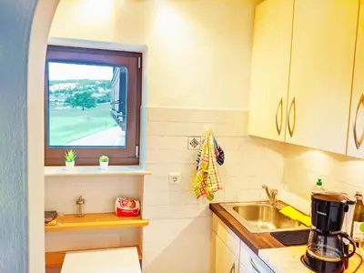 a small kitchen with a sink and a window at Vidora Apartments - Dolomites Escape in Alpe di Siusi (Seiser Alm) in Fiè