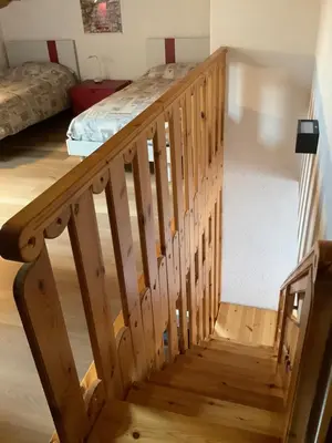 a wooden staircase in a room with a bed at Passione Dolomiti in Romeno