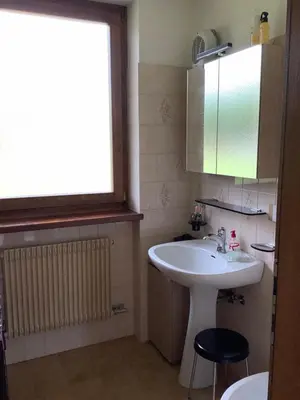 a bathroom with a white sink and a window at Passione Dolomiti in Romeno