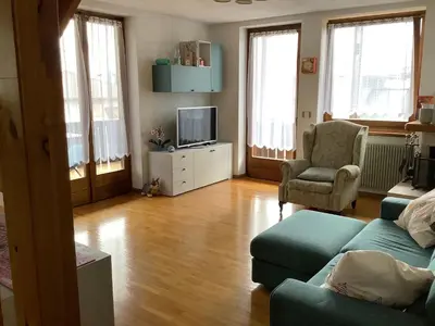 a living room with a couch and a tv at Passione Dolomiti in Romeno