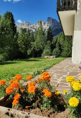 a garden with orange and yellow flowers on a path at Falcade Dolomiti La Quiete piano terra in Fregona