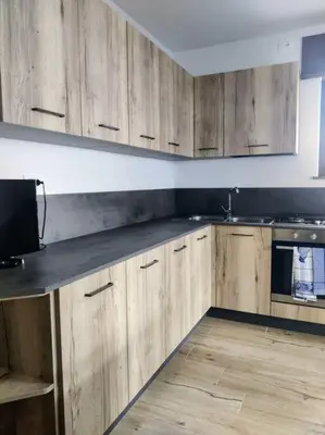 a kitchen with wooden cabinets and a counter top at Falcade Dolomiti La Quiete piano terra in Fregona
