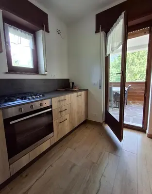 an empty kitchen with a stove and a window at Falcade Dolomiti La Quiete piano terra in Fregona