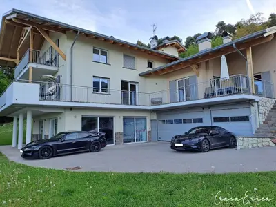 two cars parked in front of a house at Ciasa Erica - Val di Non in Predaia