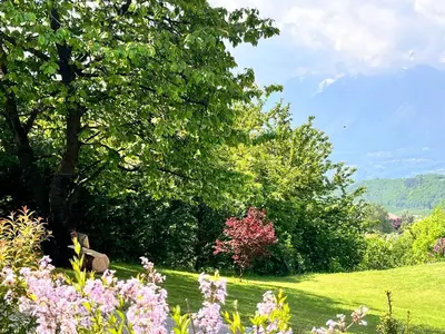 a garden with trees and flowers in a field at Ciasa Erica - Val di Non in Predaia