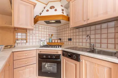 a kitchen with a sink and a stove top oven at Condominio Orsa Maggiore 12 in Falcade