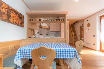 a kitchen with a table and chairs in a room at Condominio Orsa Maggiore 12 in Falcade