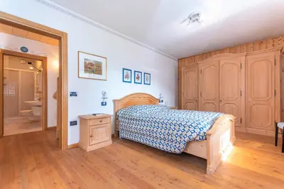 a bedroom with a bed and a bathroom at Condominio Orsa Maggiore 12 in Falcade