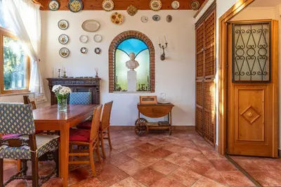a dining room with a wooden table and a window at La Villa del Barone in Predaia