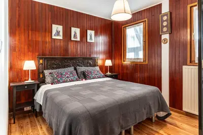 a bedroom with a bed and wood paneled walls at La Villa del Barone in Predaia