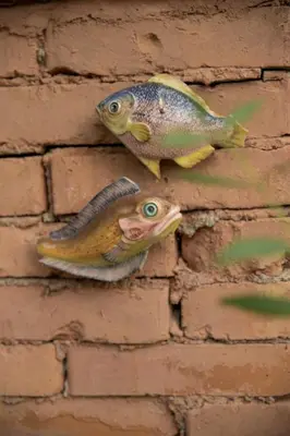 two fish hanging on a brick wall at La Villa del Barone in Predaia