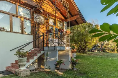 a house with a staircase in front of a building at La Villa del Barone in Predaia