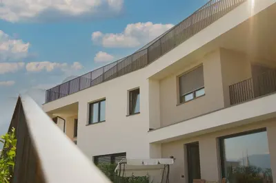 a house with a balcony and a fence at Auszait Apartments 2 in Caldaro