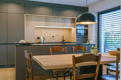 a kitchen and dining room with a wooden table and chairs at Auszait Apartments 2 in Caldaro