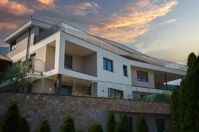 a white building on top of a stone wall at Auszait Apartments 2 in Caldaro