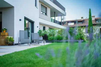 a garden with two chairs and a lawn at Auszait Apartments 2 in Caldaro