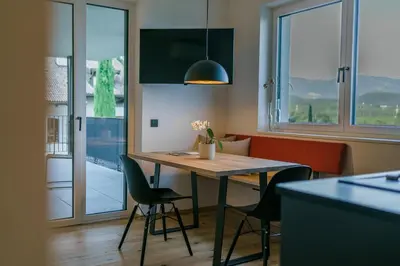 a kitchen with a table and chairs in a room at Auszait Apartments 1 in Caldaro