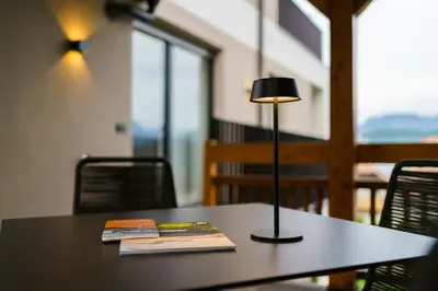 a table with a lamp and two books on it at Auszait Apartments 1 in Caldaro