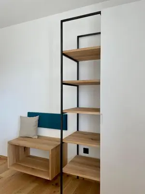 a closet with wooden shelves and a mirror at Auszait Apartments 1 in Caldaro