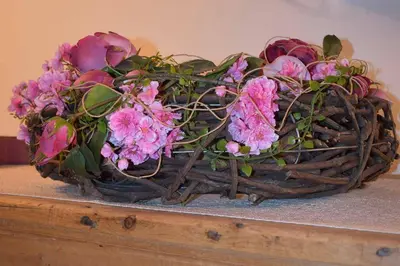 a basket filled with pink flowers on top of a table at romy's B&B in Braies