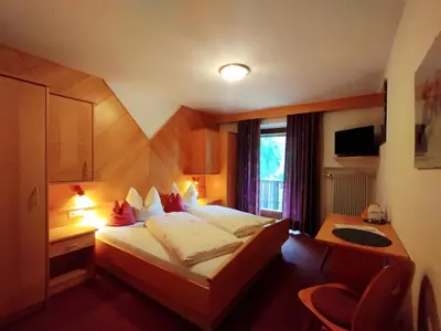 a hotel room with a bed and a desk at romy's B&B in Braies