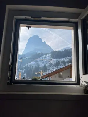 a window with a view of a mountain at Gardena SudTirol Gianni's Home in Santa Cristina in Val Gardena