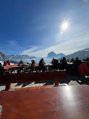 a group of people sitting at tables on a pier at Gardena SudTirol Gianni's Home in Santa Cristina in Val Gardena