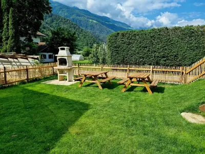 two picnic tables in a yard with a wooden fence at Gartnerhof in Plaus