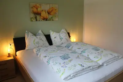 a bed with a white comforter and pillows on it at Gartnerhof in Plaus