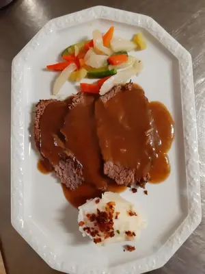 a plate of food with meat and vegetables on it at Albergo Scoiattolo in Tret