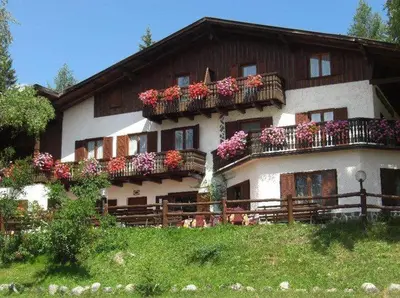 a house with flowers on the balconies of it at Albergo Scoiattolo in Tret