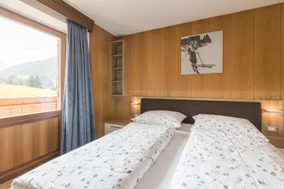 a bed in a room with a window and a bed sidx sidx sidx at B&B Ciauceia in Selva di Val Gardena