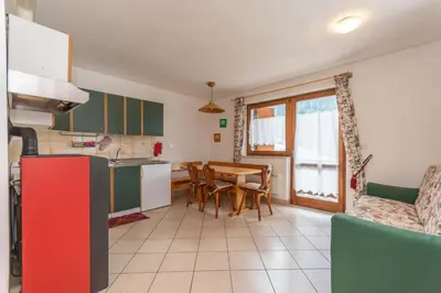 a kitchen and dining room with a table and chairs at Residenza al Villaggio in Mazzin