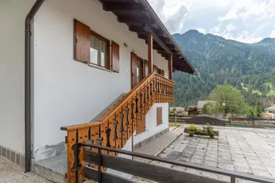 a balcony of a house with a wooden staircase at Residenza al Villaggio in Mazzin