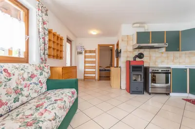 a living room with a couch and a kitchen at Residenza al Villaggio in Mazzin