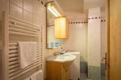 a small bathroom with a sink and a mirror at Cozy apartment near Cortina in San Vito di Cadore