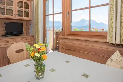 a vase of flowers on a table with a window at Leishof in Villandro