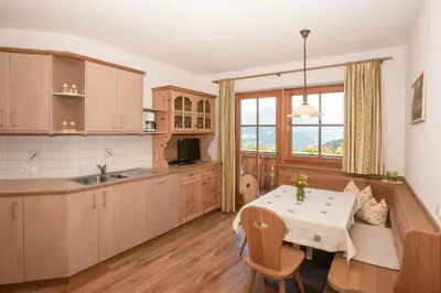a kitchen with a table and a dining room at Leishof in Villandro
