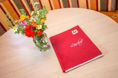 a vase of flowers and a book on a table at Leishof in Villandro