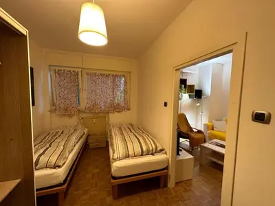 a room with two beds and a living room at Alloggio Dolomites in Bolzano