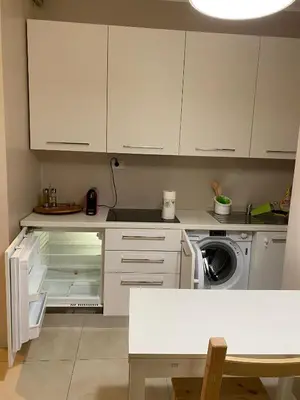 a kitchen with white cabinets and a dishwasher at Alloggio Dolomites in Bolzano