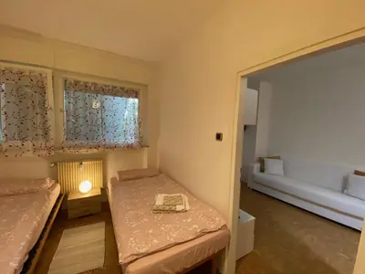 a small room with two beds and a window at Alloggio Dolomites in Bolzano