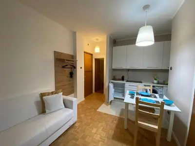 a living room with a white couch and a table at Alloggio Dolomites in Bolzano