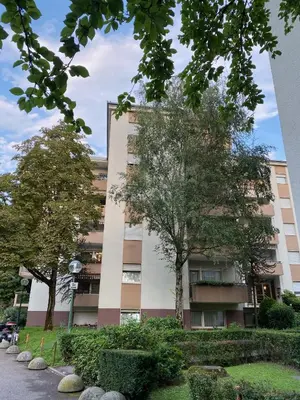 an apartment building with trees in front of it at Alloggio Dolomites in Bolzano
