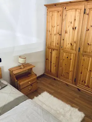 a bedroom with a bed and a wooden cabinet at Appartamento El Feudo in Tesero